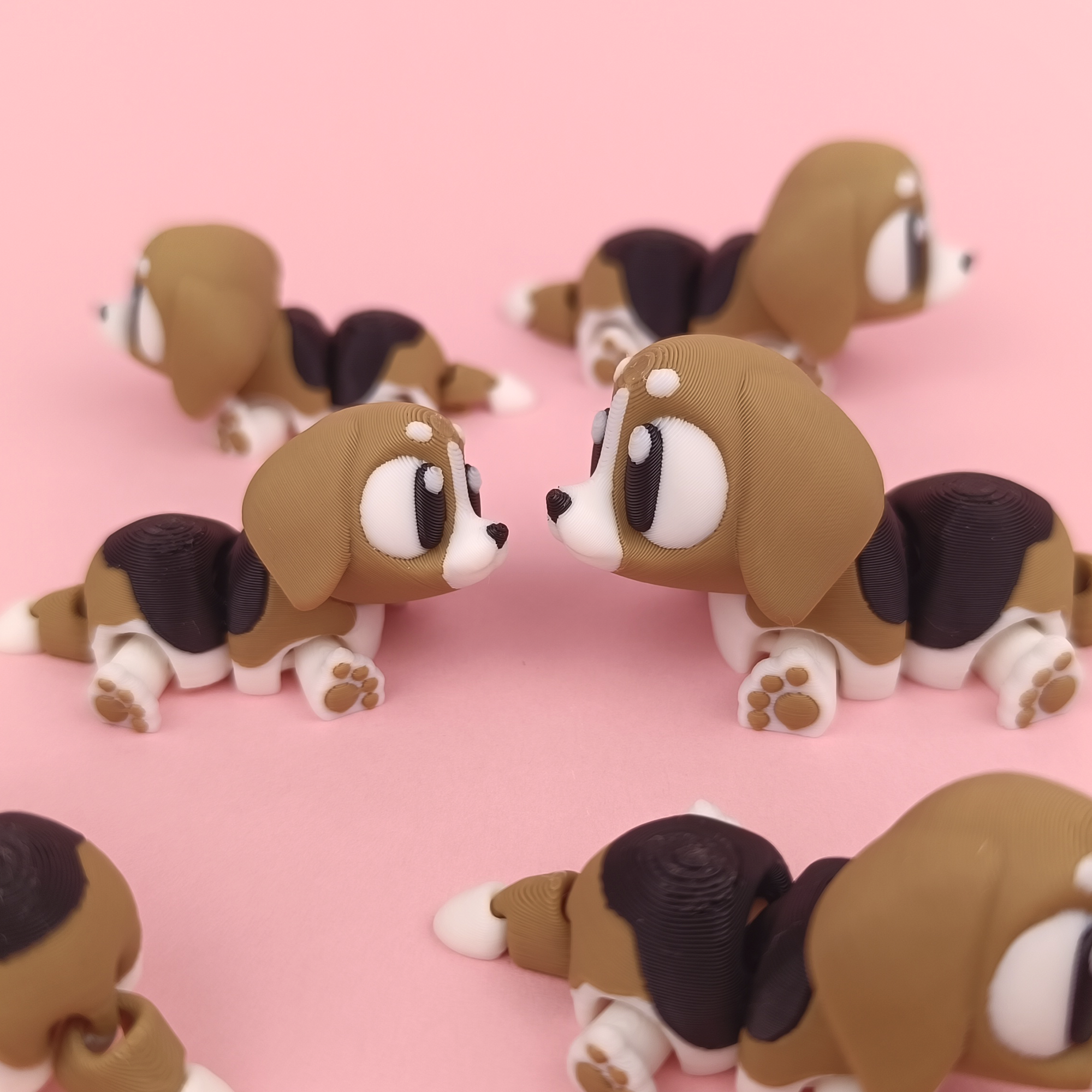 3D-gedruckte Printimon-Figur: mehrere kleine Beagle-Welpen mit großen Kulleraugen auf rosa Hintergrund.