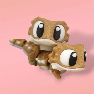 3D-gedruckte Printimon-Figur: zwei braune Bartagamen-Minis mit großen Kulleraugen auf rosa Hintergrund.